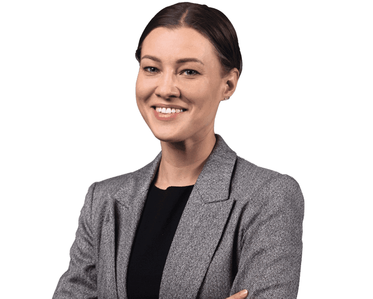 A smiling woman with her hair tied back in a gray blazer.